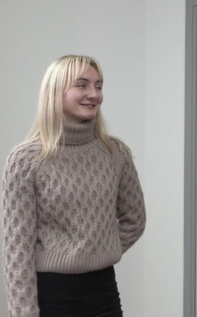 Louise Fraser Smiling young woman with blonde hair, wearing a light sweater and black trousers.